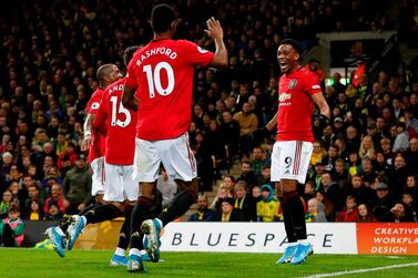 Manchester United's Anthony Martial, right, celebrates with teammates after scoring their third goal during against Norwich City at Carrow Road. AFP