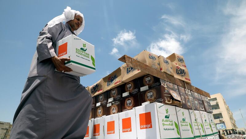 An Egyptian worker distributes food boxes by the Egyptian Food Bank to people who have lost their jobs due to the pandemic, in New Cairo, Egypt. Khaled Elfiqi / EPA