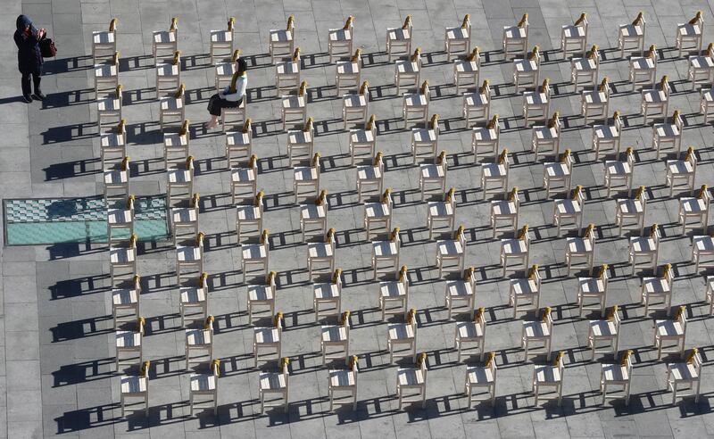 A woman takes a photo in front of a statue and empty chairs symbolising victims of comfort women in Seoul, South Korea. South Korea announced on Wednesday a review of the 2015 agreement between South Korea and Japan over South Korea's comfort women issue. Lee Jin-man / AP