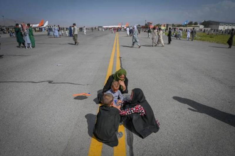Afghans on the tarmac at Kabul airport in Kabul after a swift end to the 20-year war in the country. Thousands of people mobbed the city's airport trying to flee the group's rule.