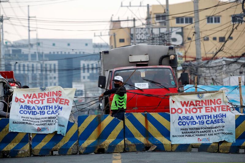 A village security officer mans a road blockade at the border between Bacoor City, Cavite province and Las Piñas City, Metro Manila. EPA