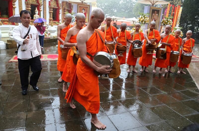Wild Boars football coach Ekkapol Chanthawong, front, and the rescued members of the football team attend a Buddhist ceremony as they prepare to be ordained as Buddhist monks and novices in the Mae Sai district, Chiang Rai, Thailand, on July 25, 2018. AP Photo