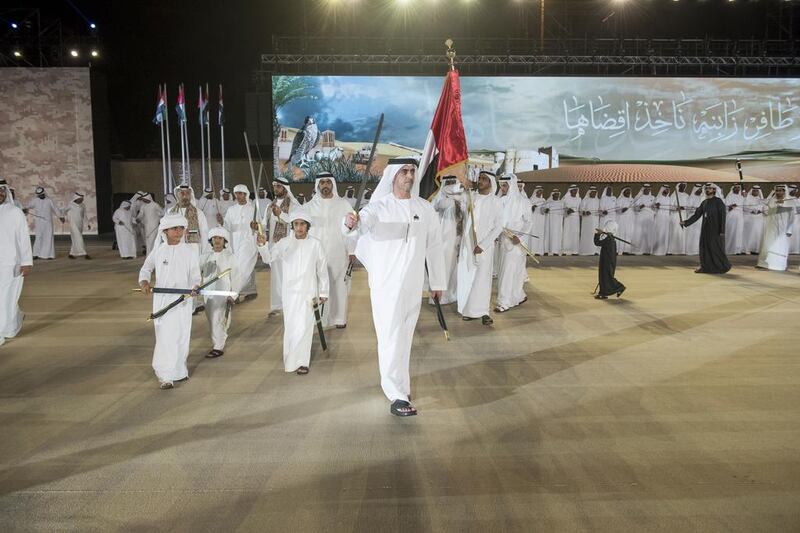 Lt General Sheikh Saif bin Zayed Al Nahyan, Deputy Prime Minister and Minister of Interior, centre, dances during the National Day celebrations. Rashed Al Mansouri / Crown Prince Court - Abu Dhabi