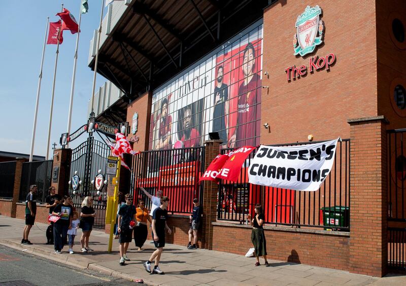 Liverpool fans mingle next to the Kop end of Anfield. EPA