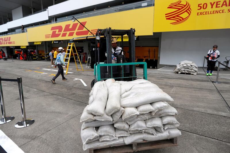 Sandbags are moved into the pitlane due to the approach of Typhoon Hagibis. Reuters