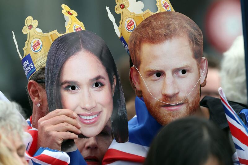 Fans holding masks with the faces of Prince Harry and Meghan wait for them to conduct a public walkabout at the Vivaduct Harbour. AFP