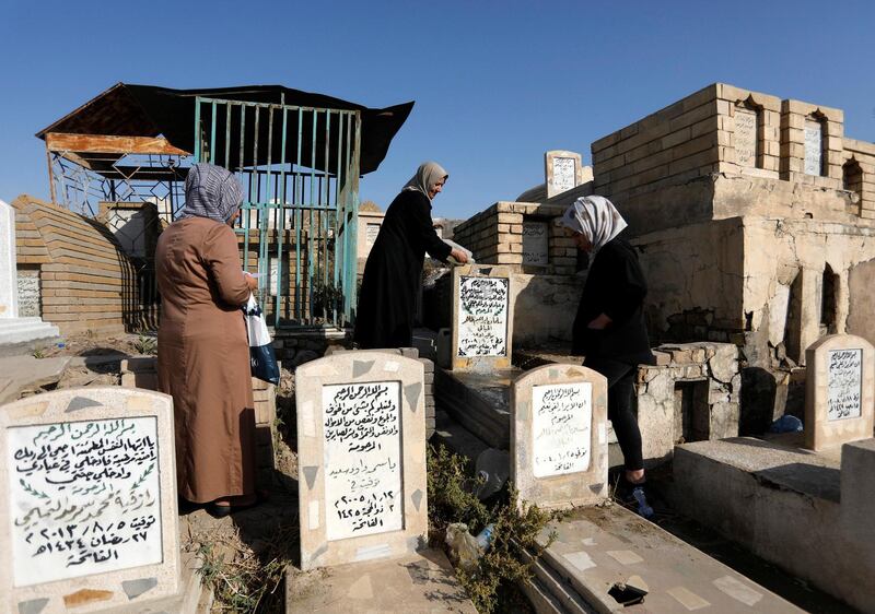 A family cleans the grave of their father at a cemetery during Eid Al Fitr, marking the end of the fasting month of Ramadan, in Baghdad, Iraq. Reuters
