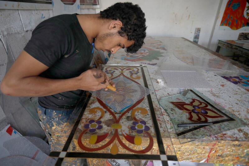 epa08566292 A Yemeni artist draws patterns on a plastic panel at a workshop in Sana'a, Yemen, 25 July 2020. Yemeni artists have started their own small businesses at a workshop in Sana'a to draw and paint patterns on plastic and glass panels as a way to improve the income in their war-ridden country.  EPA/YAHYA ARHAB