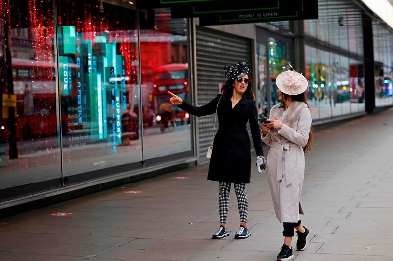 Pedestrians outside a closed store in central London. AFP