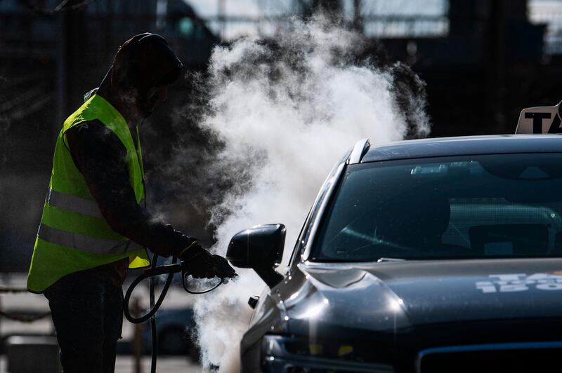 A man cleans and desinfects a taxi car in Stockholm, Sweden, on April 2, 2020, to prevent the spread of the coronavirus, AFP