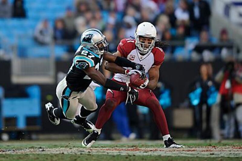 Larry Fitzgerald, right, makes a reception under pressure against the Carolina Panthers.