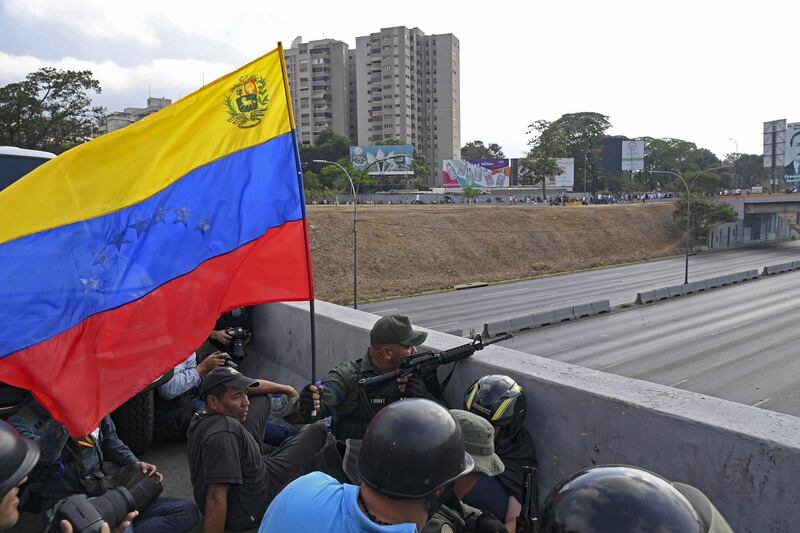 Soldiers supporting Mr. Guaido take position in front of La Carlota base. AFP