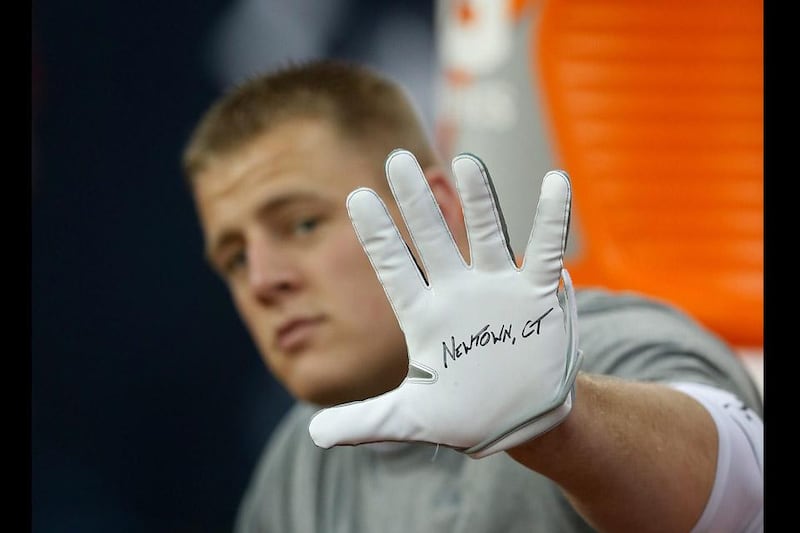 J.J. Watt of the Houston Texans displays a glove to remember the victims of the massacre at Sandy Hook Elementary School in Newtown, Conn. prior to the start of the game against the Indianapolis Colts. Scott Halleran / Getty Images