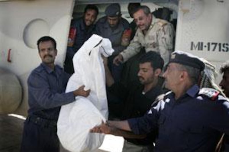 Yemeni soldiers and health workers carry one of three retrieved bodies of the kidnapped foreigners off a military helicopter in San'a, Yemen, on June 16 2009.