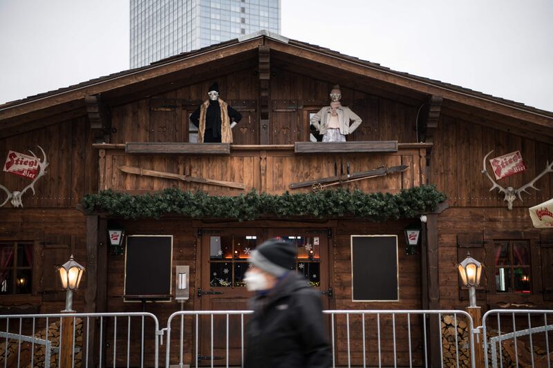 A person wearing a face mask walks past a booth of a yet to be opened Christmas market in Berlin. AFP