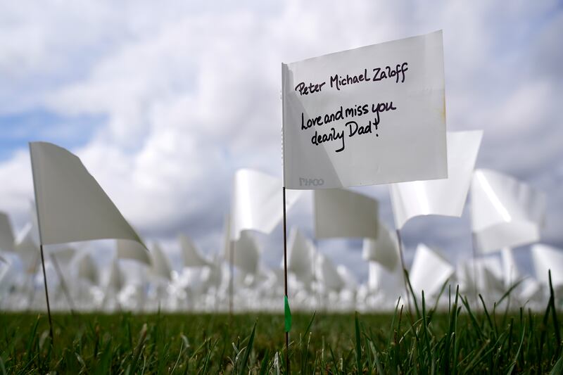 A message marks a white flag that is part of artist Suzanne Brennan Firstenberg's "In America: Remember," a temporary art installation to commemorate Americans who have died of COVID-19, on the National Mall in Washington, Tuesday, Sept.  21, 2021.  (AP Photo / Patrick Semansky)