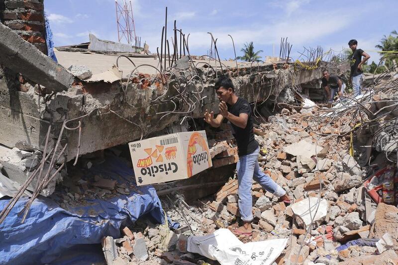 A man removes a box of food from under the rubble of a building that collapsed after the earthquake in Pidie Jaya. Heri Juanda / AP Photo
