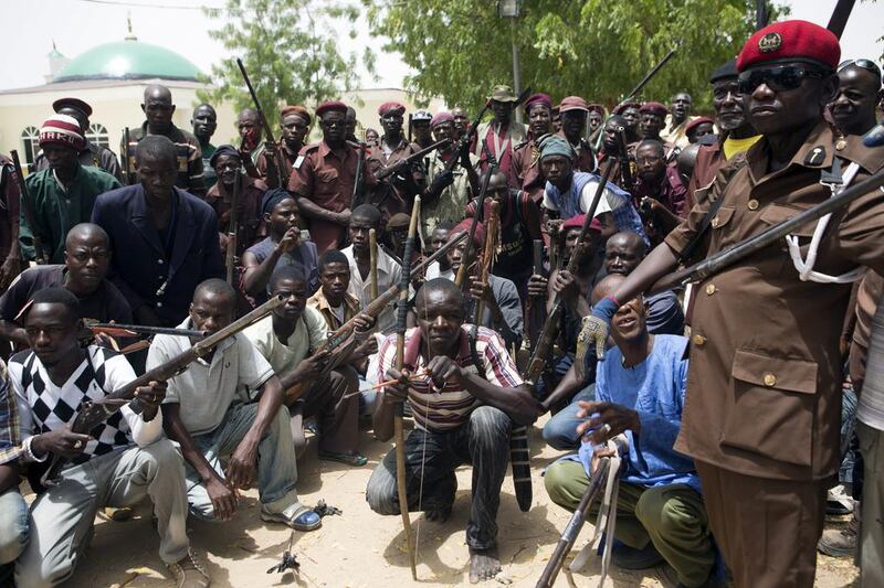 A vigilante group of traditional hunters at their camp in Maiduguri May 21, 2014. About 100 traditional hunters from villages in Borno state have gathered in a camp in Maiduguri and volunteered to hunt for Boko Haram to help the local government, which provides them two meals per day, they say. Joe Penney/Reuters