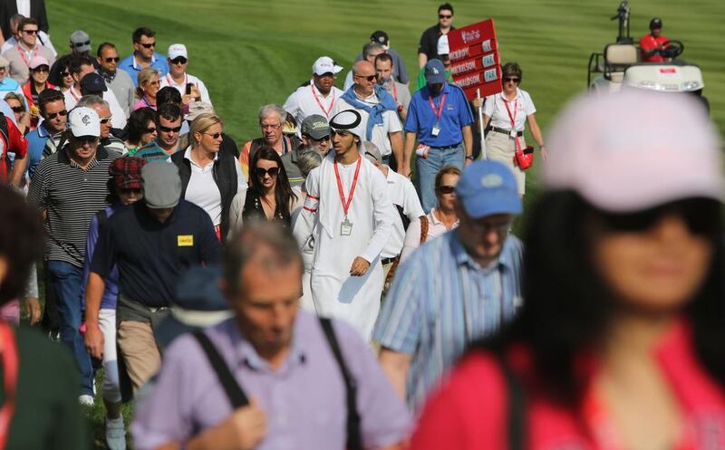 An Emirati and fans of different nationalities attend the first round of the Abu Dhabi HSBC Golf Championship. Now in its 10th year, the event has become a firm fixture on the calendars of golfers the world over. Kamran Jebreili / AP 

