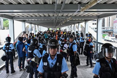 Police stand guard on a footbridge near the government headquarters a day after a violent demonstration against a controversial extradition law proposal in Hong Kong on June 13, 2019. AFP