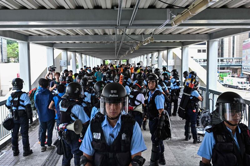 Police stand guard on a footbridge near the government headquarters a day after a violent demonstration against a controversial extradition law proposal in Hong Kong on June 13, 2019. Asian markets fell again on June 13 with Hong Kong suffering a second straight day of heavy losses as investors fret over the impact of protests in the city and plans to introduce a controversial law allowing extradition to China. / AFP / Anthony WALLACE
