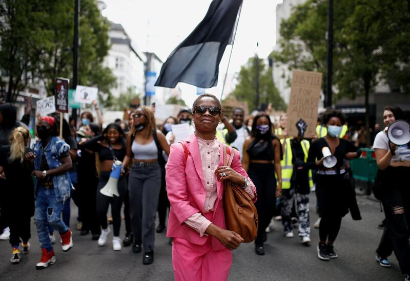A demonstrator smiles as people march to Westminster during a Black Lives Matter protest, following the death of George Floyd in Minneapolis police custody, in London, Britain. REUTERS