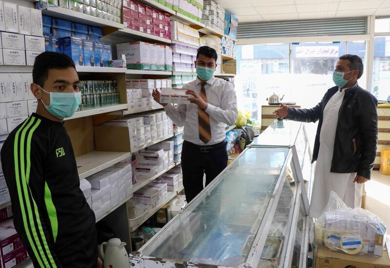 An Afghan man buys face masks in a pharmacy in Herat province. Reuters