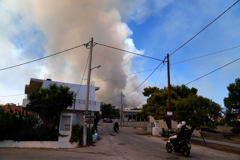 Police patrol during a wildfire in Agios Konstantinos, about 60 kilometres south of Athens.
