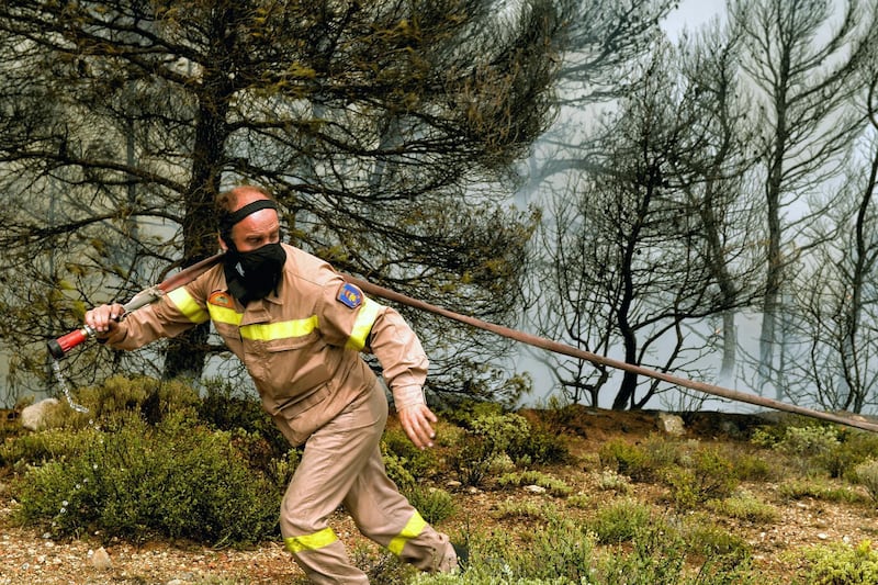 A firefighter works to extinguish a wildfire raging in Verori, near Loutraki city, Peloponnese. EPA
