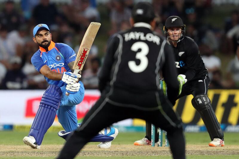 India's Virat Kohli (L) bats watched by New Zealand's Tom Latham (R) during the third one-day international cricket match between New Zealand and India at Bay Oval in Mount Maunganui on January 28, 2019. / AFP / MICHAEL BRADLEY
