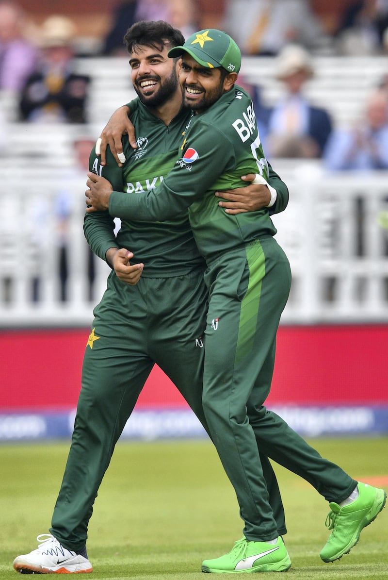 Pakistan's Shadab Khan (L) celebrates with teammate Babar Azam after the dismissal of South Africa's Aiden Markram during the 2019 Cricket World Cup group stage match between Pakistan and South Africa at Lord's Cricket Ground  in London on June 23, 2019. (Photo by SAEED KHAN / AFP) / RESTRICTED TO EDITORIAL USE