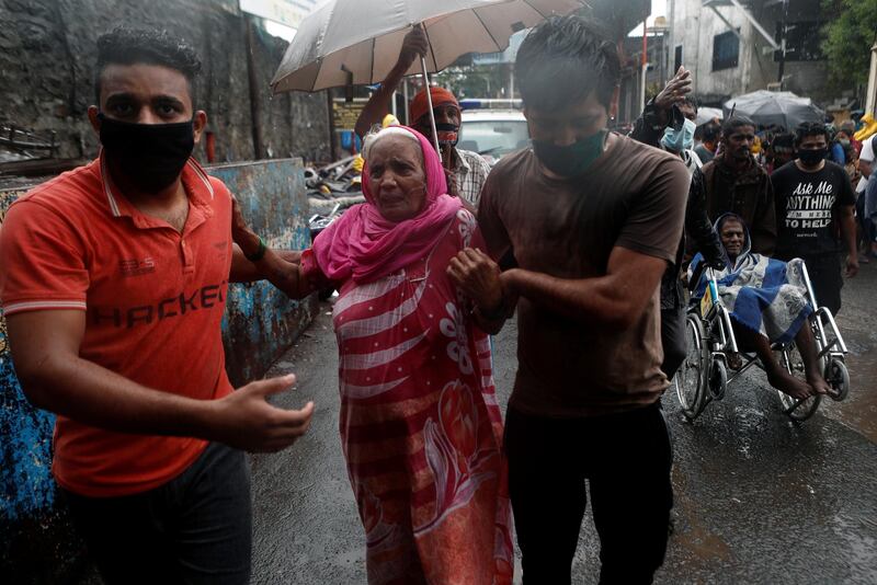 People help elderly citizens during an evacuation from a slum on the outskirts of the city, in Mumbai, India. Reuters