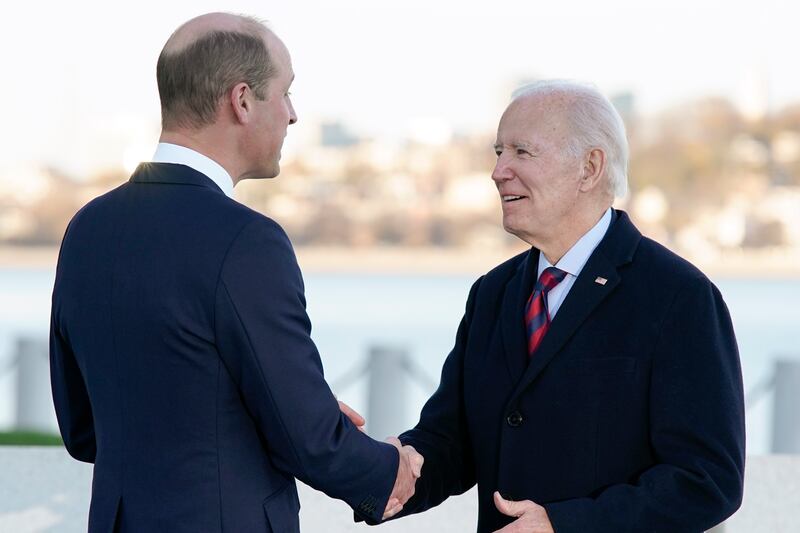 Mr Biden shakes hands with Prince William as they meet outside the venue. AP
