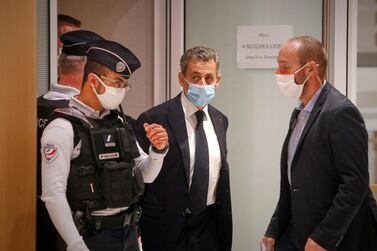 Former French President Nicolas Sarkozy (centre) arrived in court wearing a mask. Getty
