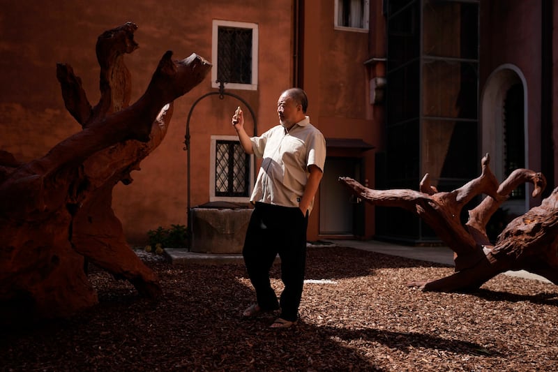 Chinese artist Ai Weiwei takes pictures with a smartphone of his wooden sculpture.