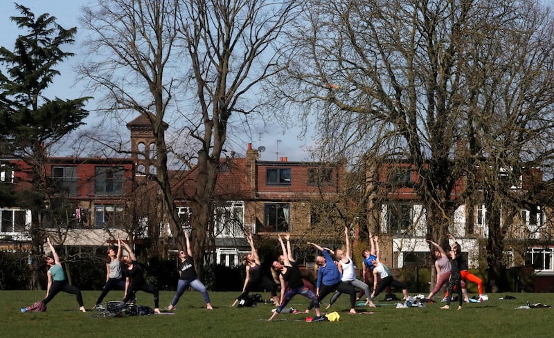 A goup of women exercise in a park in London. AP Photo