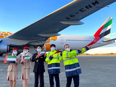 Emirates staff in Tokyo celebrate the UAE's 49th National Day under the wing of a jet. Courtesy Emirates 