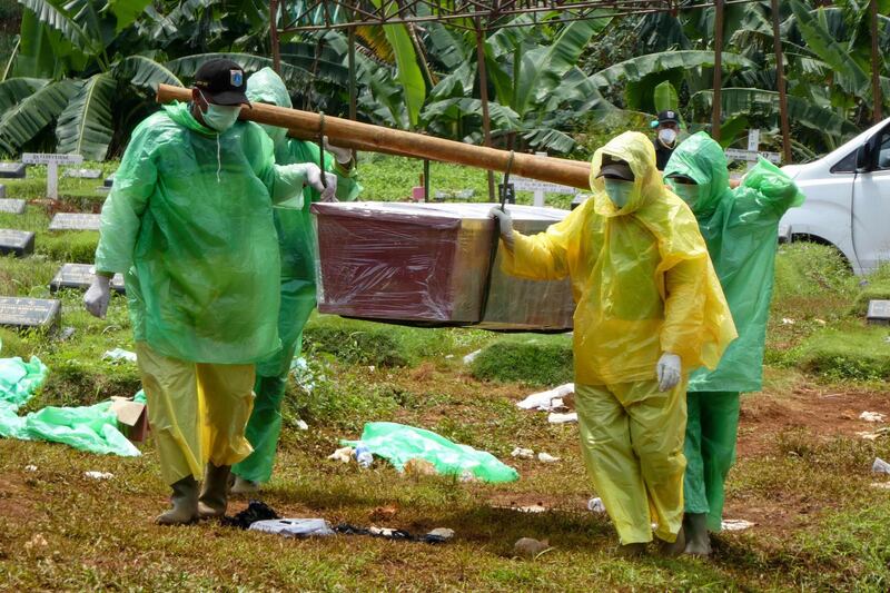 Workers carry a coffin of a victim of the COVID-19 coronavirus during a funeral in Jakarta.  AFP