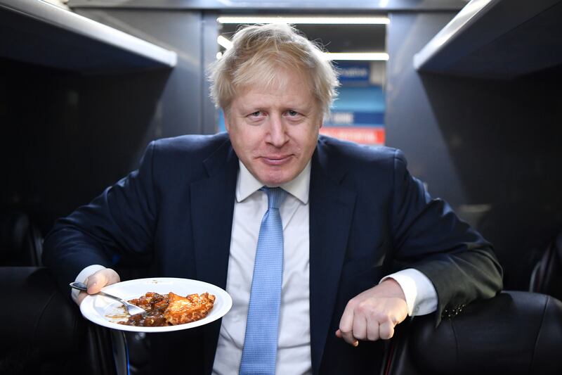 Mr Johnson eats pie on the campaign bus in Derby, on the final day of campaigning before the general election in December 2019. Getty Images