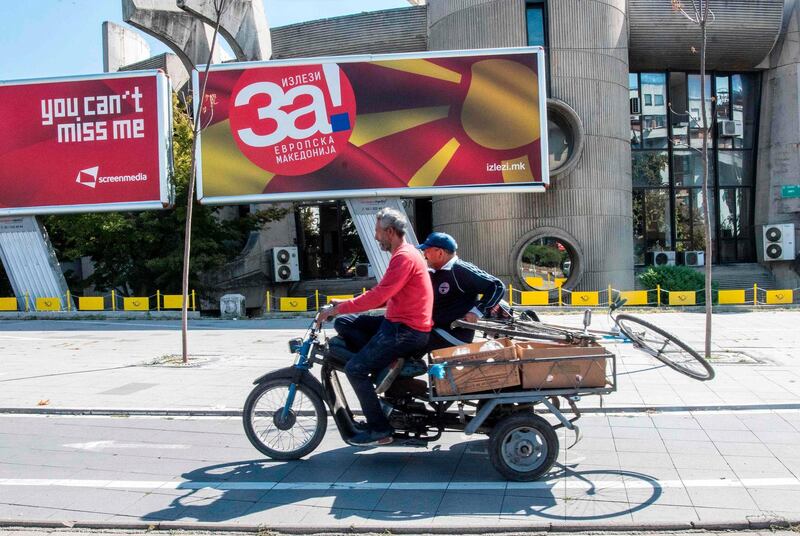 A man drives a motorcycle in front of a campaign bilboard announcing the referendum on the renaming of the country in Skopje on October 1, 2018.  Macedonia's prime minister vowed to push ahead with changing the country's name after voters approved it in a referendum, but the outcome looked uncertain on October 1 as opponents said low turnout made the result void. / AFP / Robert ATANASOVSKI
