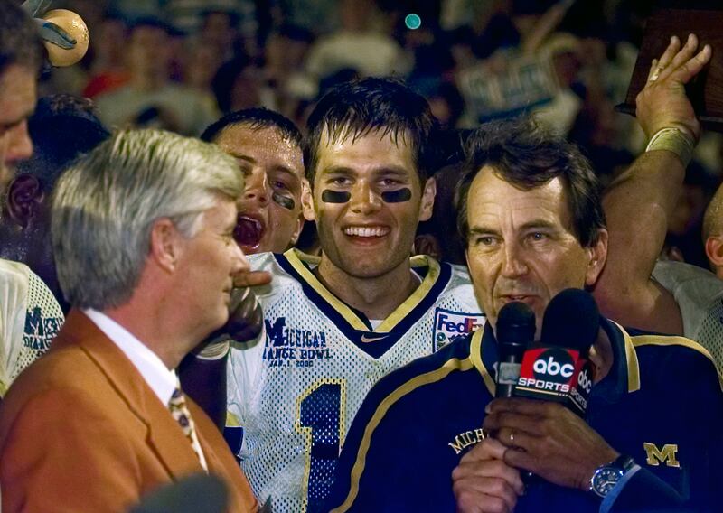 Michigan quarterback Tom Brady behind coach Lloyd Carr after a 35-34 overtime win against Alabama at the FedEx Orange Bowl NCAA college game in Miami Gardens in January, 2000. AP