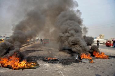Anti-government protesters set fires to close a highway during ongoing protests in downtown Baghdad. AP