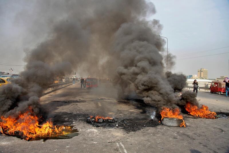Anti-government protesters set fires to close a highway during ongoing protests in downtown Baghdad, Iraq, Sunday, Jan. 19, 2020. Black smoke filled the air as protesters burned tires to block main roads in the Iraqi capital Baghdad, expressing their anger at poor services and shortages despite religious and political leaders calling for calm. (AP Photo/Khalid Mohammed)