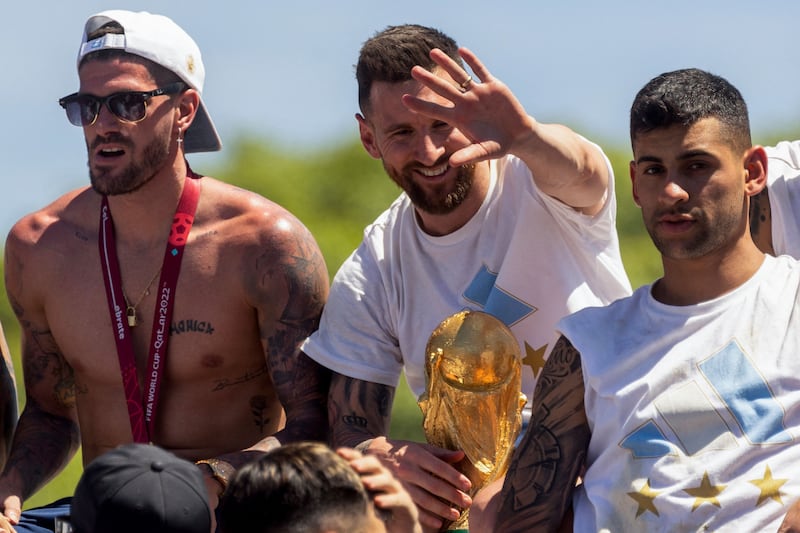 Argentina World Cup winners Rodrigo De Paul, Lionel Messi and Cristian Romero celebrate on board an open-top bus as they parade through Buenos Aires on December 20, 2022. AFP