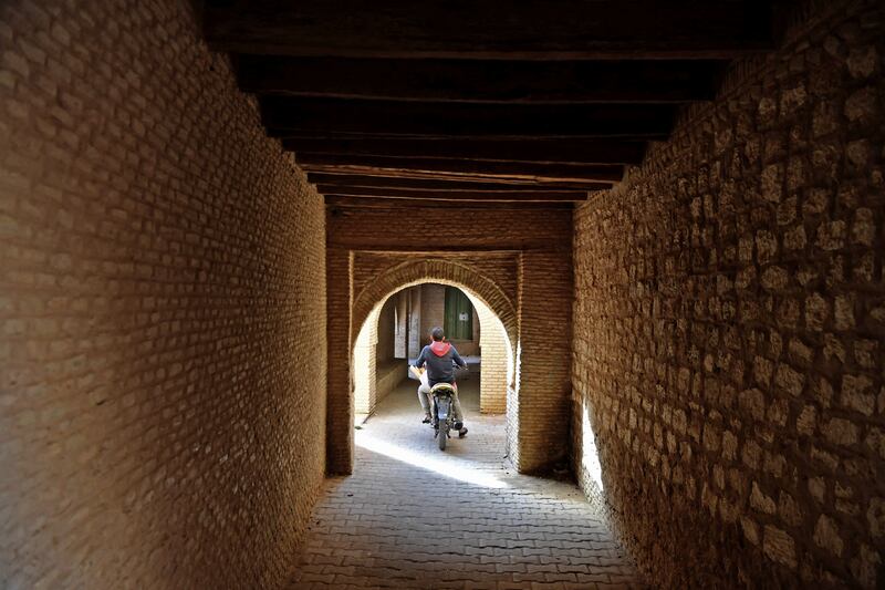 A boy rides a bicycle in a residential area of Nefta.