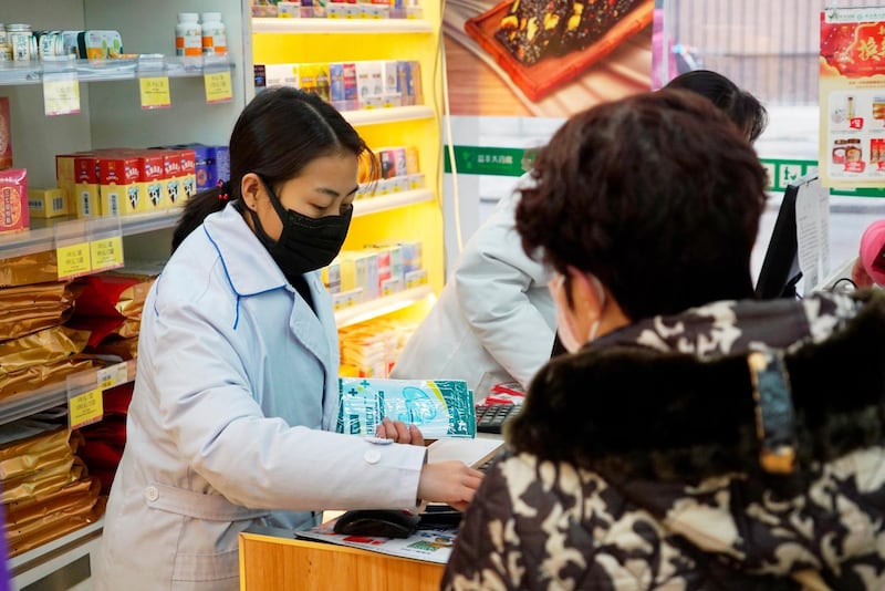 Staff sell masks at a Yifeng Pharmacy in Wuhan, Chin. AP Photo