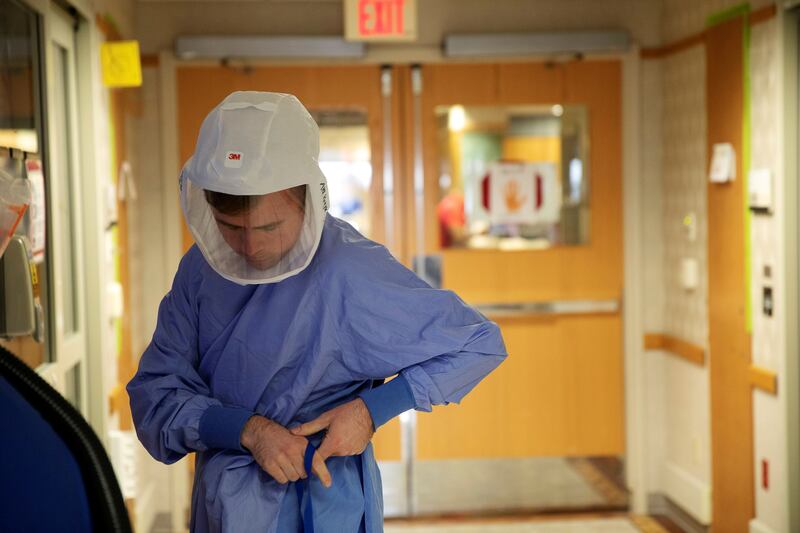 Nurse Alex Krajek puts on PPE as he prepares to enter a patient room in a wing housing Covid-19 patients at UW Health University Hospital in Madison, Wisconsin. Reuters