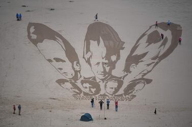 Activists put the finishing touches to a sand drawing of the G7 leaders, calling on them to 'share the vaccine' on Watergate Bay beach near Newquay, Cornwall ahead of the three-day G7 summit. AFP