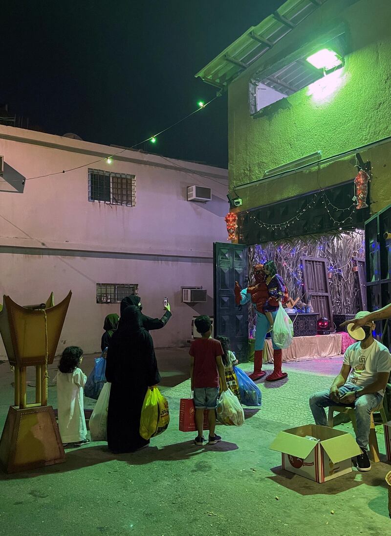 A woman takes a photo of her child with a man dressed as Spiderman during Gargee'an in Qatif, Saudi Arabia. Reuters