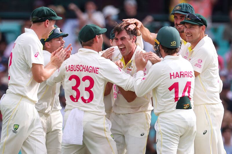 Australia's captain Pat Cummins (C) reacts with team mates after taking the wicket of England's Jos Buttler on day five of the fourth Ashes cricket test between Australia and England at the Sydney Cricket Ground (SCG) on January 9, 2022.  (Photo by DAVID GRAY  /  AFP)